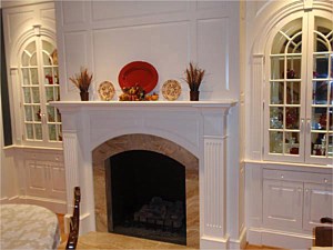 Custom fireplace surround, windows, and cabinetry created